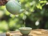 Hand-picked specialty loose leaf tea poured from a celadon teapot